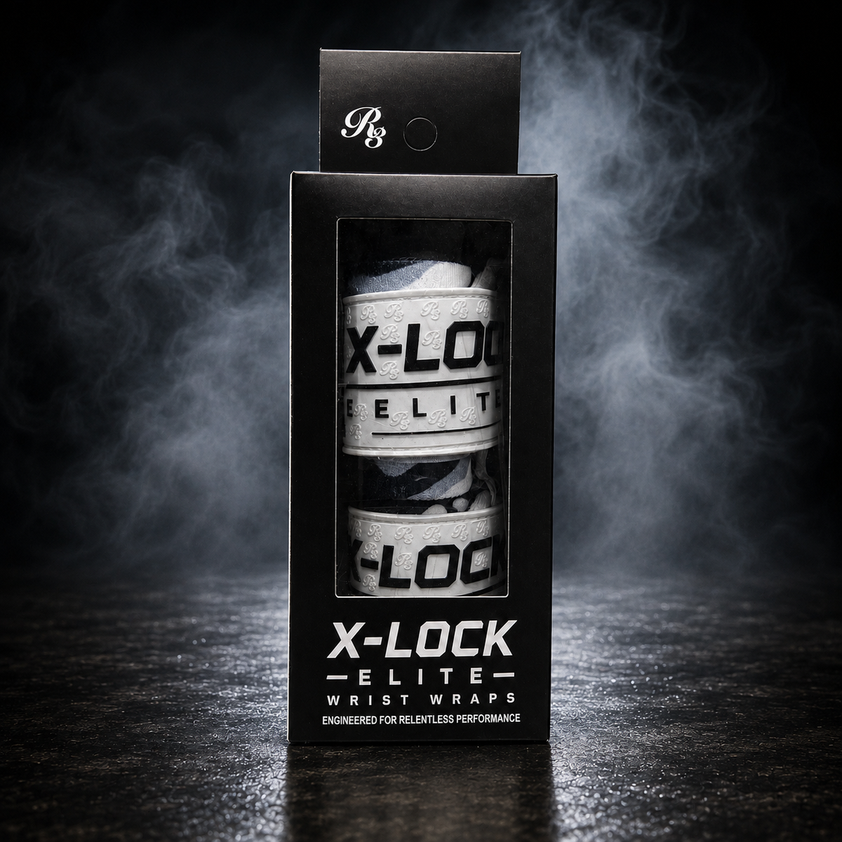 A black retail box for X-LOCK Elite Wraps, showing two white and black wrist wraps inside a clear window, photographed on a dark smoky studio background.