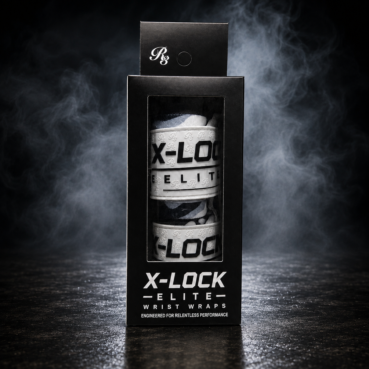 A black retail box for X-LOCK Elite Wraps, showing two white and black wrist wraps inside a clear window, photographed on a dark smoky studio background.