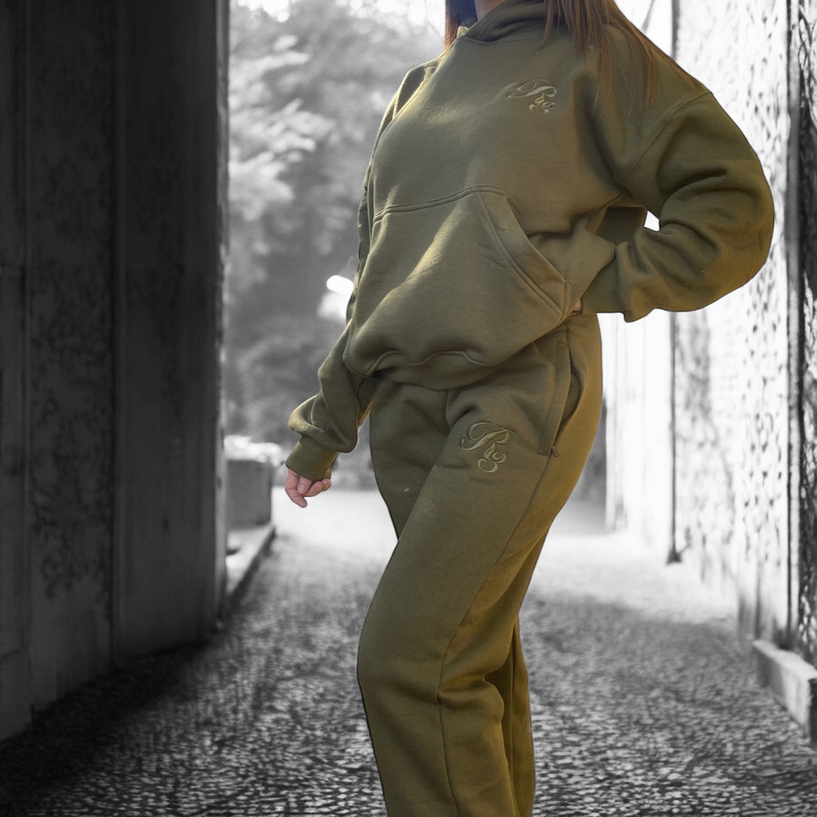 A person wearing a gray Coz3 Max Hoodie with the hood up, standing in a snowy outdoor setting.