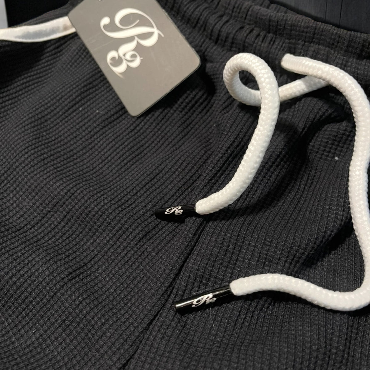 Lazer engraved logo on string tips of thermal material yoga shorts